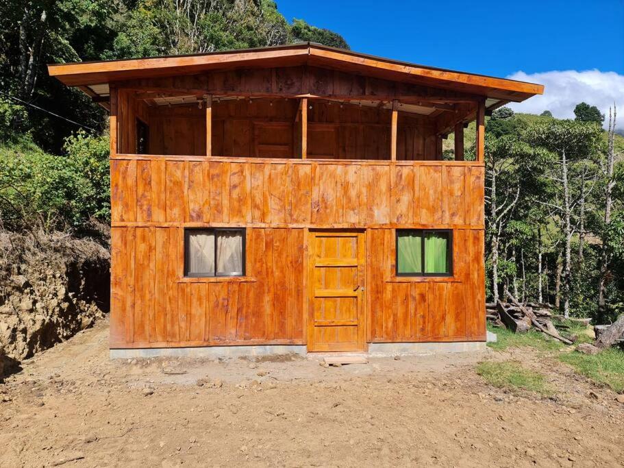 eine Holzhütte mit einer Tür im Schmutz in der Unterkunft Cabaña El Angel in Alaska