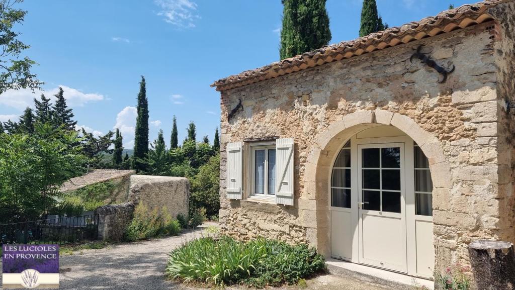 una entrada a un edificio de piedra con una puerta blanca en Le Mazet, gîte des Lucioles en Provence, en Montségur-sur-Lauzon