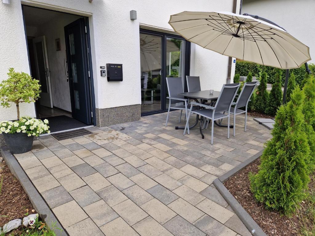 a patio with a table and an umbrella at Ferienwohnung in Olpe-Rhode am Biggesee in Olpe