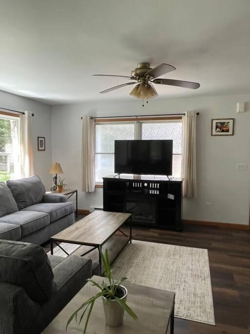 a living room with a couch and a flat screen tv at Falls Edge Farm Cottage in Benton