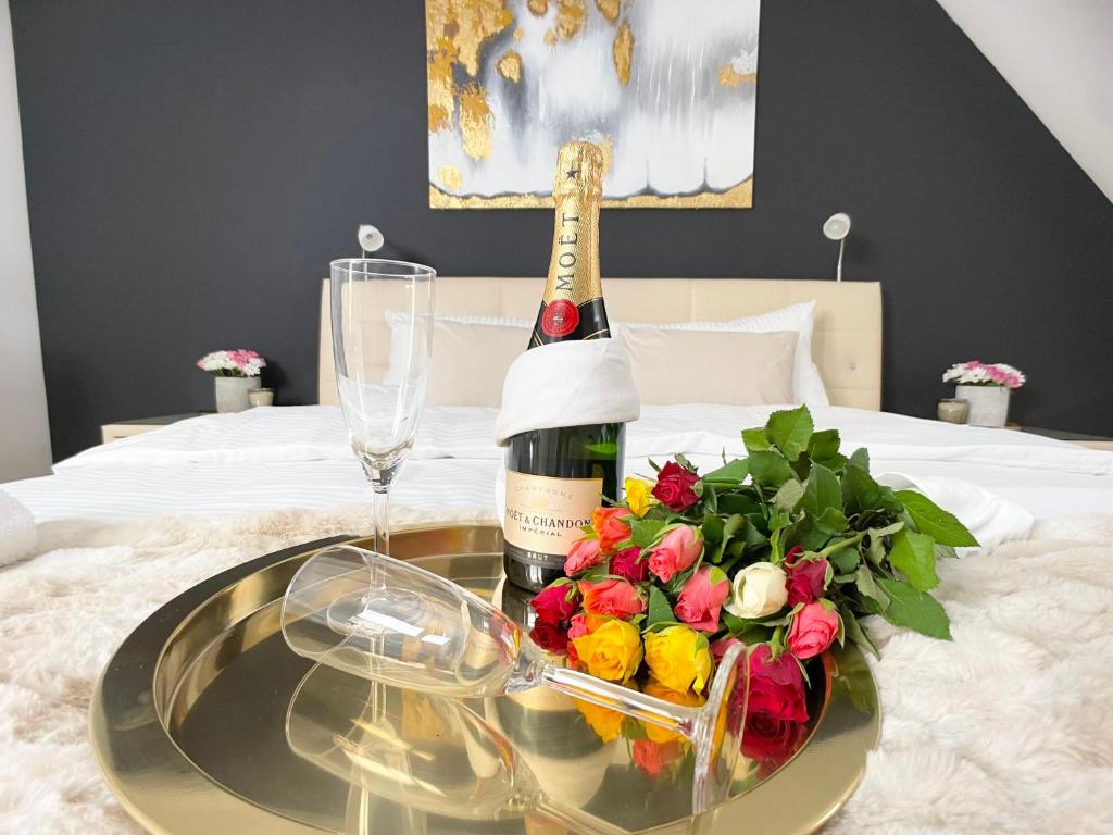 a glass table with a bottle of wine and flowers on a bed at M-Style 04 Apartment mit Balkon und Gasgrill, 24h Self-Check-In, Free Parking, Netflix in Nürnberg