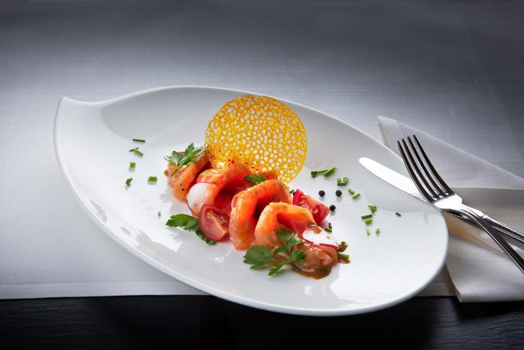 a plate of food with a fruit on it at Garden & SPA Hotel Das Götzfried in Regensburg