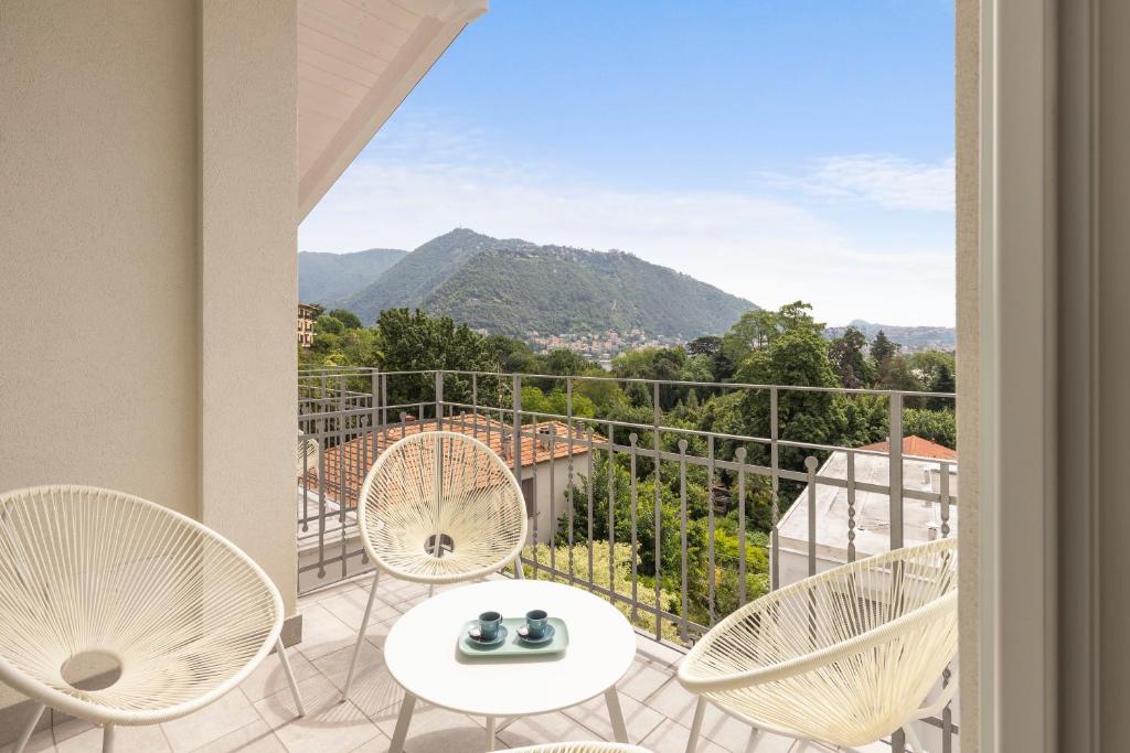 einen Balkon mit Stühlen und einem Tisch mit Aussicht in der Unterkunft Olmo Suites in Como