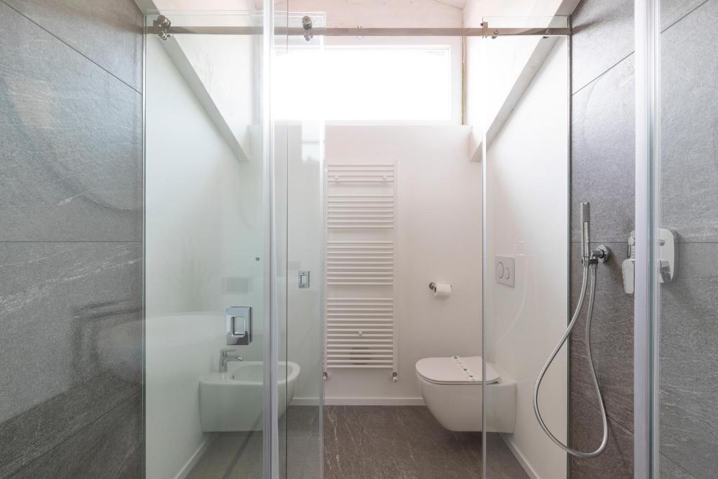 een badkamer met een douche, een toilet en een wastafel bij Olmo Suites in Como