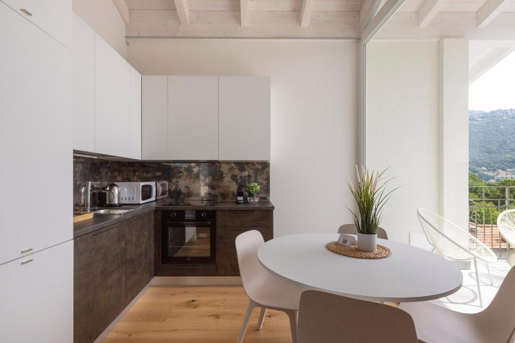 een witte keuken met een witte tafel en stoelen bij Olmo Suites in Como