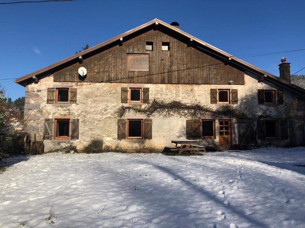 un granero de piedra grande con nieve delante en La Louve, en Basse-sur-le-Rupt