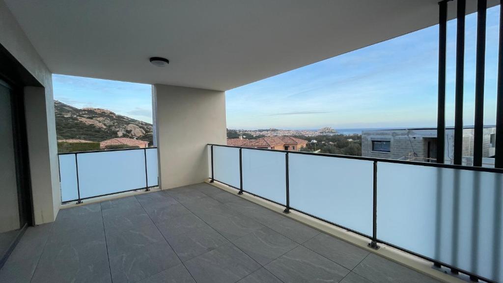 un balcon vide avec vue sur les montagnes dans l'établissement Calvi 2 pièces NEUF - vue mer piscine 18 m - proche plage - location par semaine complète, à Calvi