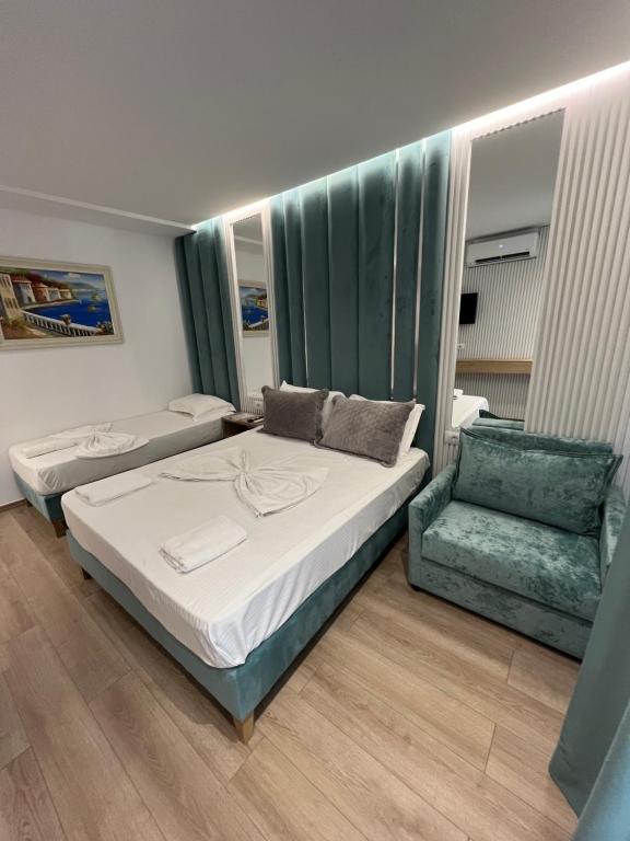 a bedroom with a bed and a chair in it at Ilio Boutique Hotel in Ksamil