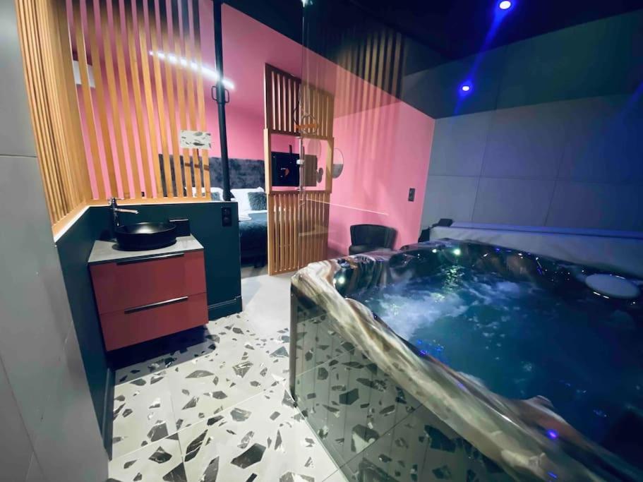 La Litchi Le 50 Suites and Spa centre ville في بوردو: حمام مع حوض كبير ومغسلة