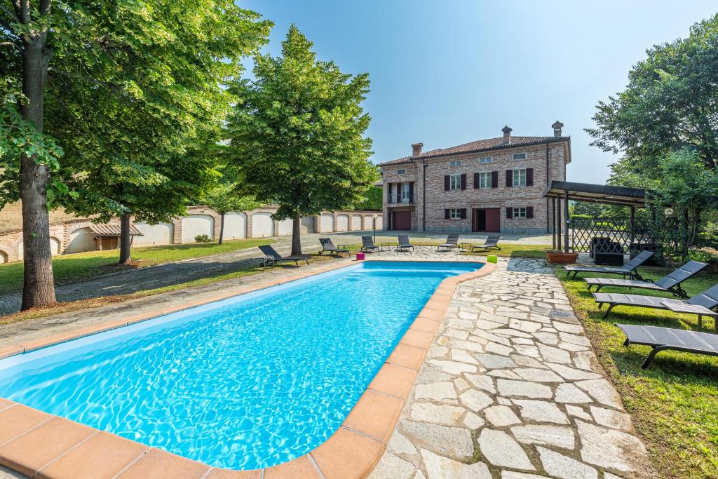 une piscine en face d'un bâtiment dans l'établissement Villa Cornelia , entire Villa with private pool, à Corneliano d'Alba