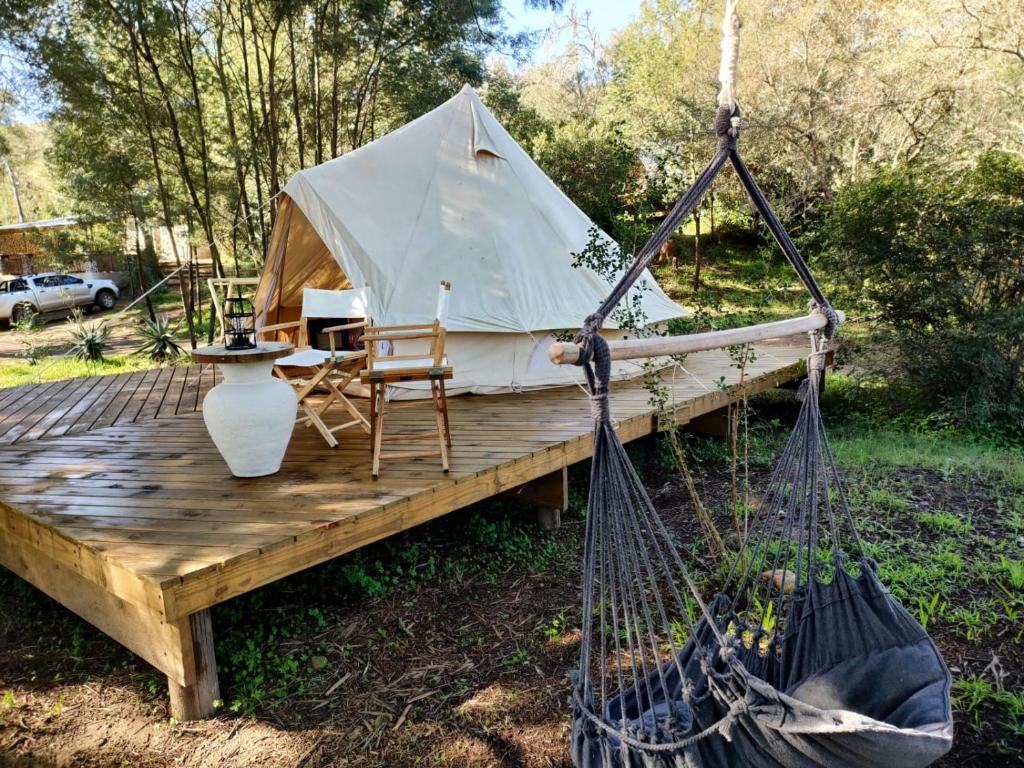 a yurt with a chair on a wooden deck at Gaia Double bell tent in Swellendam
