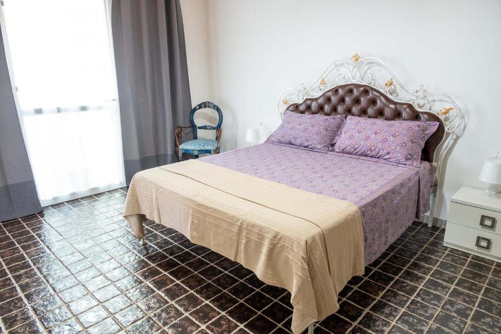 una camera da letto con letto con lenzuola viola e cuscini viola di Delta House a Taglio di Po
