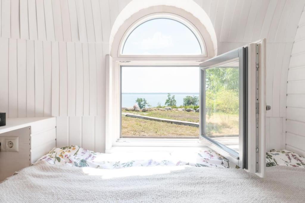 a bedroom with a bed and an open window at Igluhut on the South Coast of Lohusalu 200m from the Sea! in Lohusalu