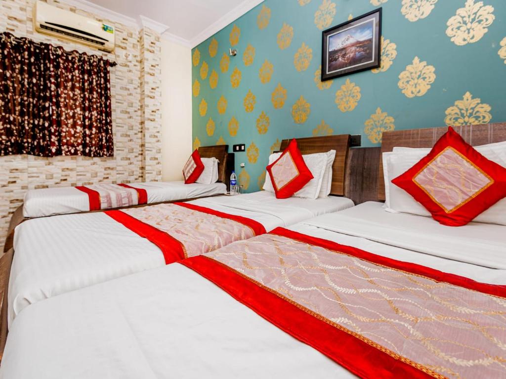 Un grupo de 4 camas en una habitación en NEW ROYAL LODGE, en Mangalore