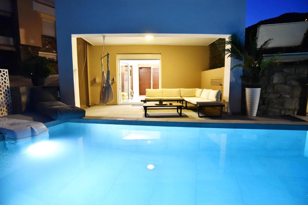 Una gran piscina frente a una sala de estar. en SUNRISE LUXURY POOL VILLA, en Palaión Tsiflíkion
