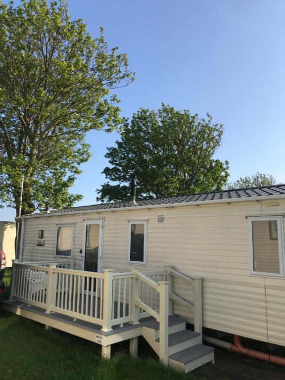 a mobile home with a porch and a deck at Holiday Caravan, Pebble Bank in Wyke Regis