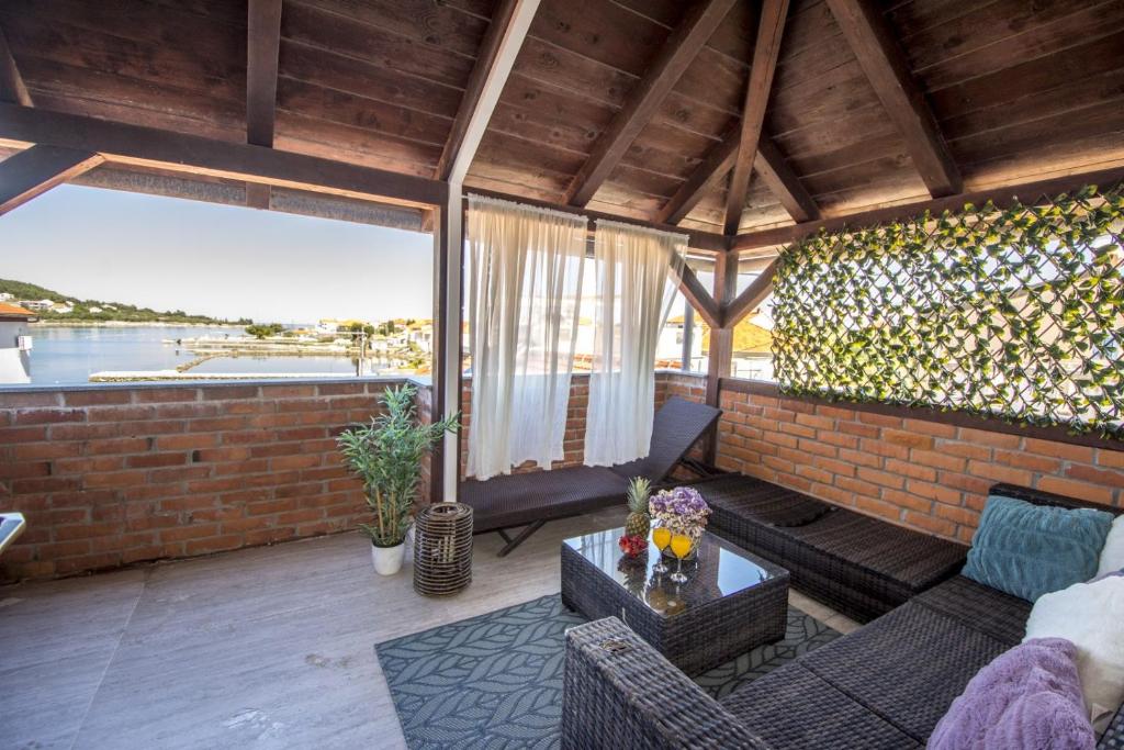 uma sala de estar com um sofá e uma mesa em Kuća na plaži em Preko