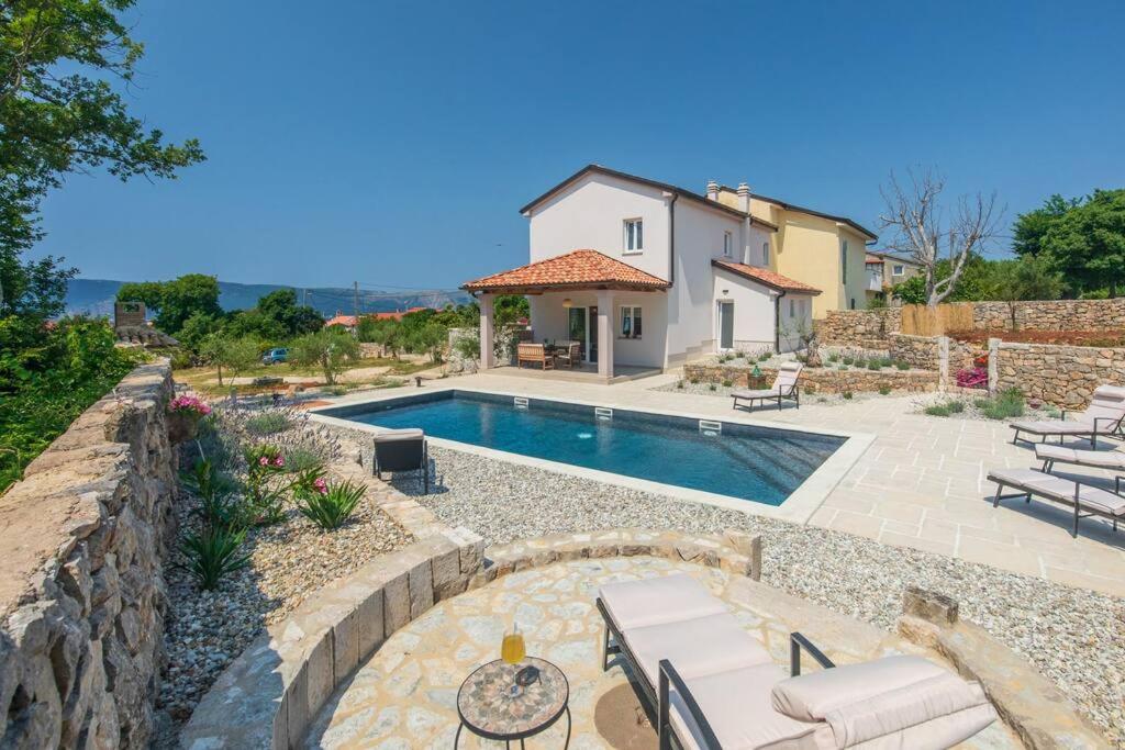 eine Villa mit einem Pool und einem Haus in der Unterkunft Villa Albina in Skrbčići