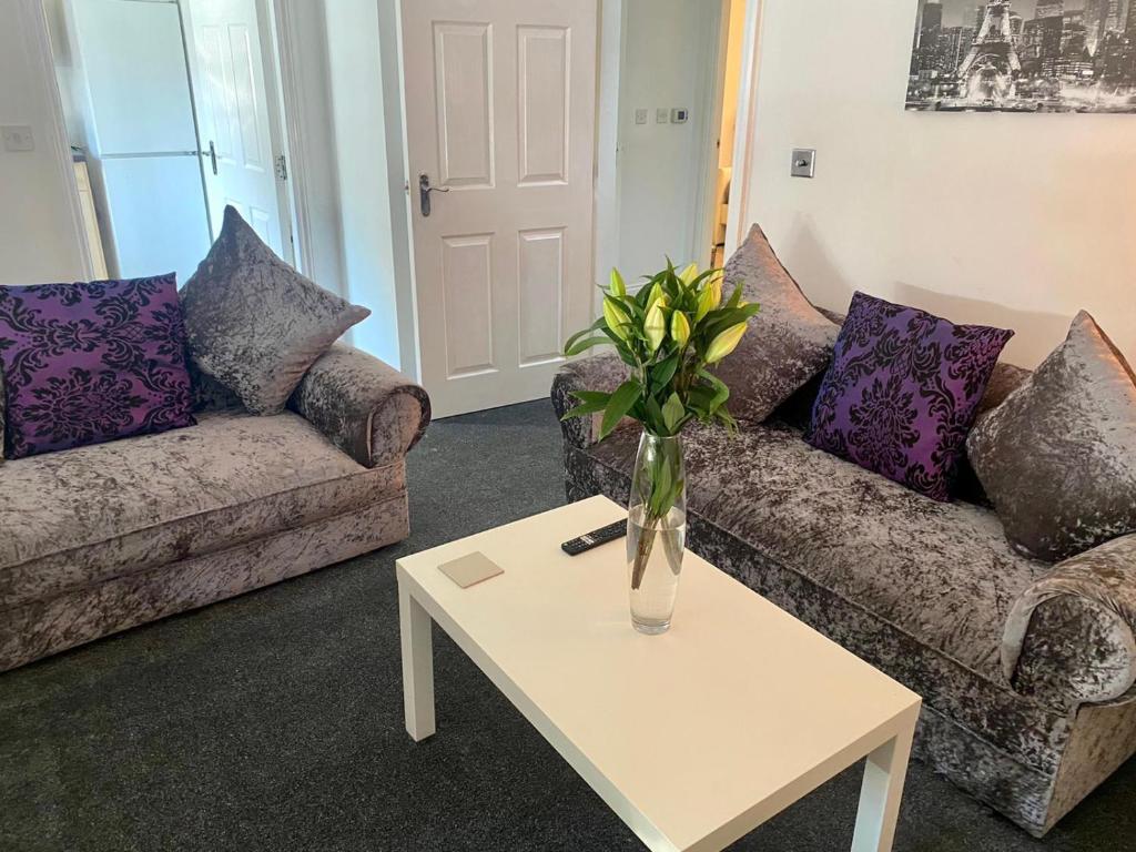 a living room with two couches and a vase on a table at Sedgefield luxury Apartments. in Sedgefield