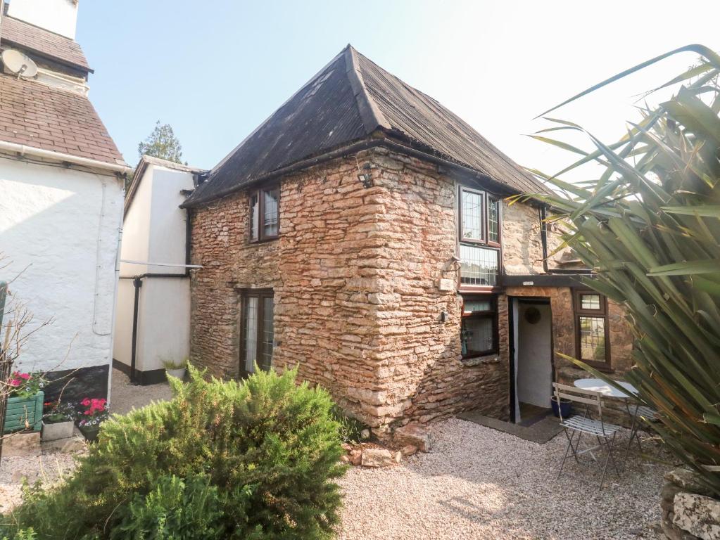 an old brick house in a garden at Lilac Cottage in Paignton