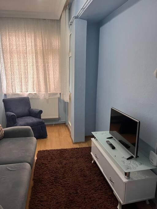 a living room with a couch and a tv on a table at Şehir Merkezinde Konforlu Daire in Istanbul
