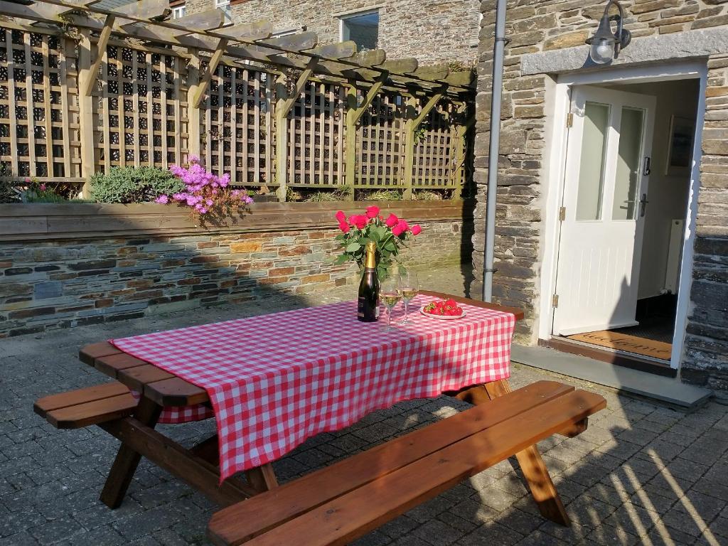una mesa de picnic con un mantel a cuadros rojo y blanco en The Mill en Tintagel