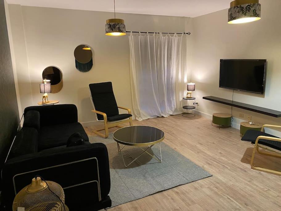 ein Wohnzimmer mit einem Sofa und einem TV in der Unterkunft piso lagunero in La Laguna