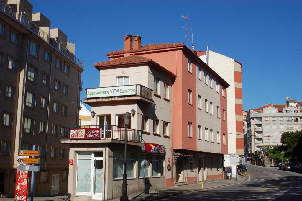 un edificio en la esquina de una calle con edificios en Apartamentos VIDA Sanxenxo, en Sanxenxo