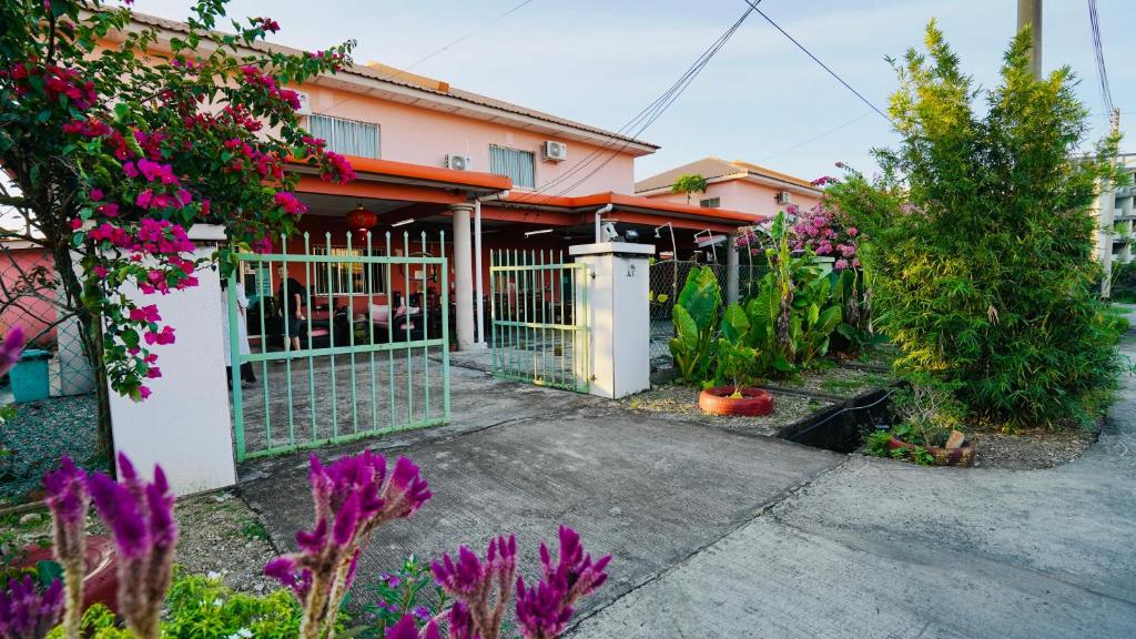 a fence in front of a house with flowers at HUAQIAO HOME 侨之家免费供早餐free breakfast served in Semporna