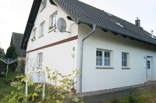 Biały dom z czarnym dachem w obiekcie Ruegen_Fewo 54 Melina w mieście Blieschow