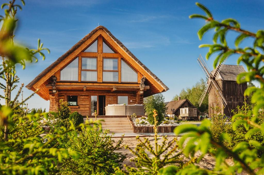 a house with a large window and a windmill at Willa Alpejska in Konin