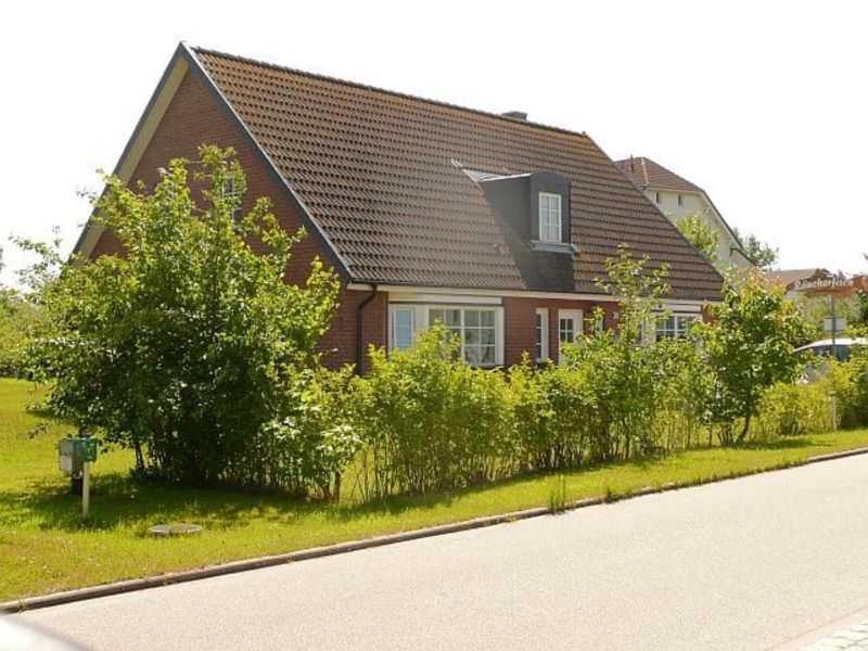 a brown house with a fence in front of it at Ruegen_Fewo 230 in Thiessow