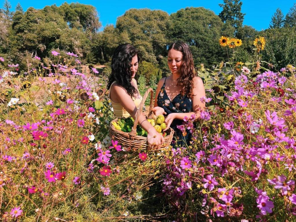 dos mujeres de pie en un campo de flores en The Land - Luxury Retreat Center In Beautiful Nature - Bay Area Northern California, en Philo