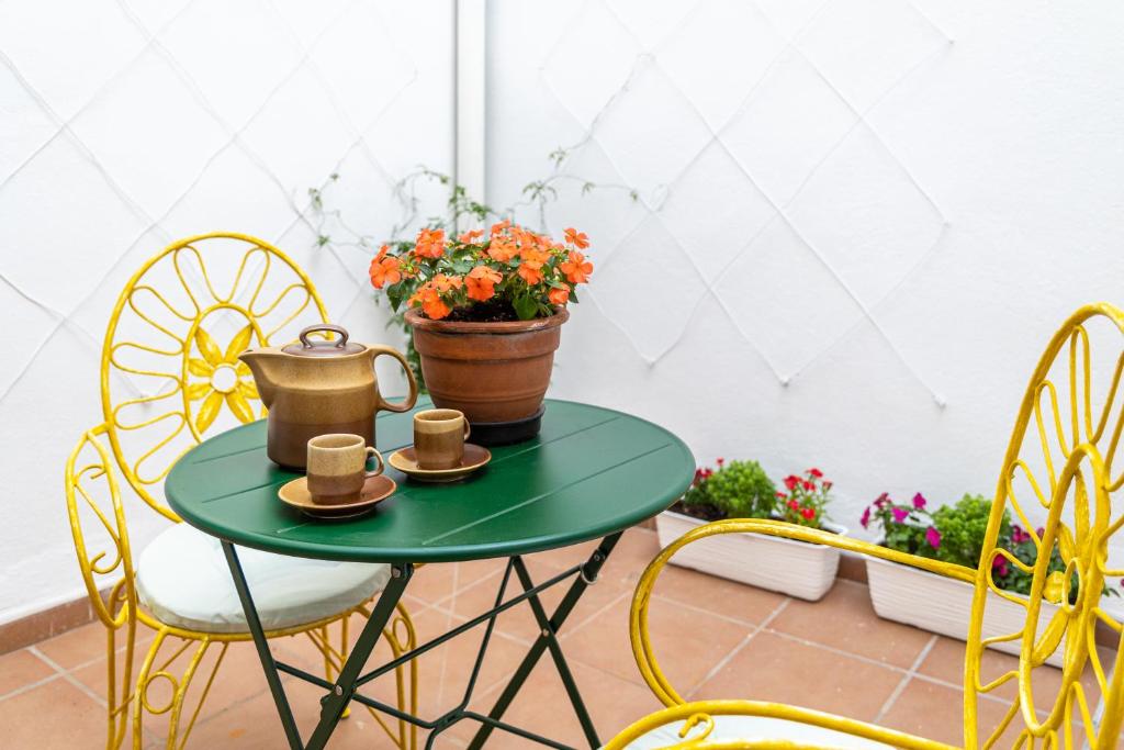 Hotel Twins NEST Malaga, a green table with two chairs and a plant at Twins NEST Malaga in Málaga