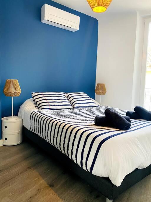 une chambre avec un lit avec un mur bleu dans l'établissement Magnifique appartement t2, à Collobrières