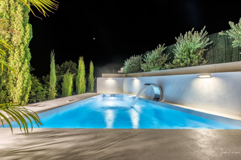 uma piscina à noite com uma fonte em Bayton House em Los Llanos de Aridane