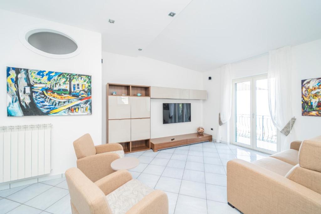 uma sala de estar com duas cadeiras e uma televisão em Residenza Sant'Angelo - Art Apartment em Minori