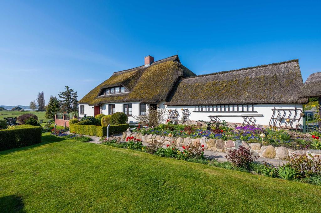 a white house with a garden in front of it at Ruegen Fewo 22 in Alt Reddevitz