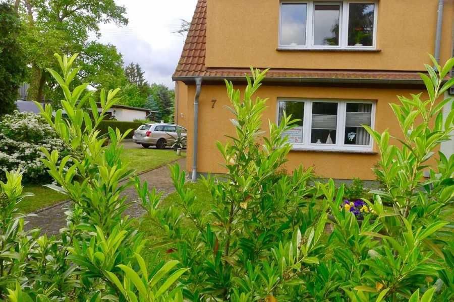 a house with a bush in front of it at Ferienwohnung Muschelbank_ MV_Fewo in Stralsund