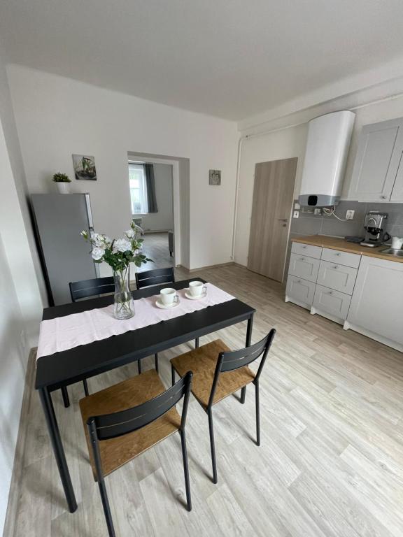 einen Esstisch mit 2 Stühlen und eine Küche in der Unterkunft Apartmán Fifejdy, Ostrava, centrum in Ostrava