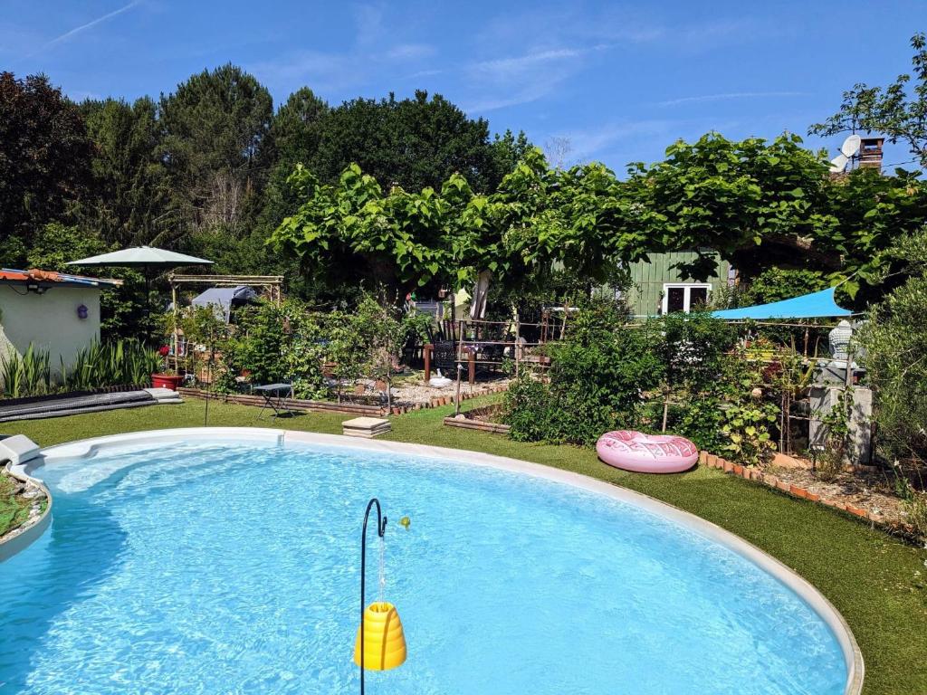 a large swimming pool with a toy in a yard at Au ' Bord des Landes ' in Cazalis