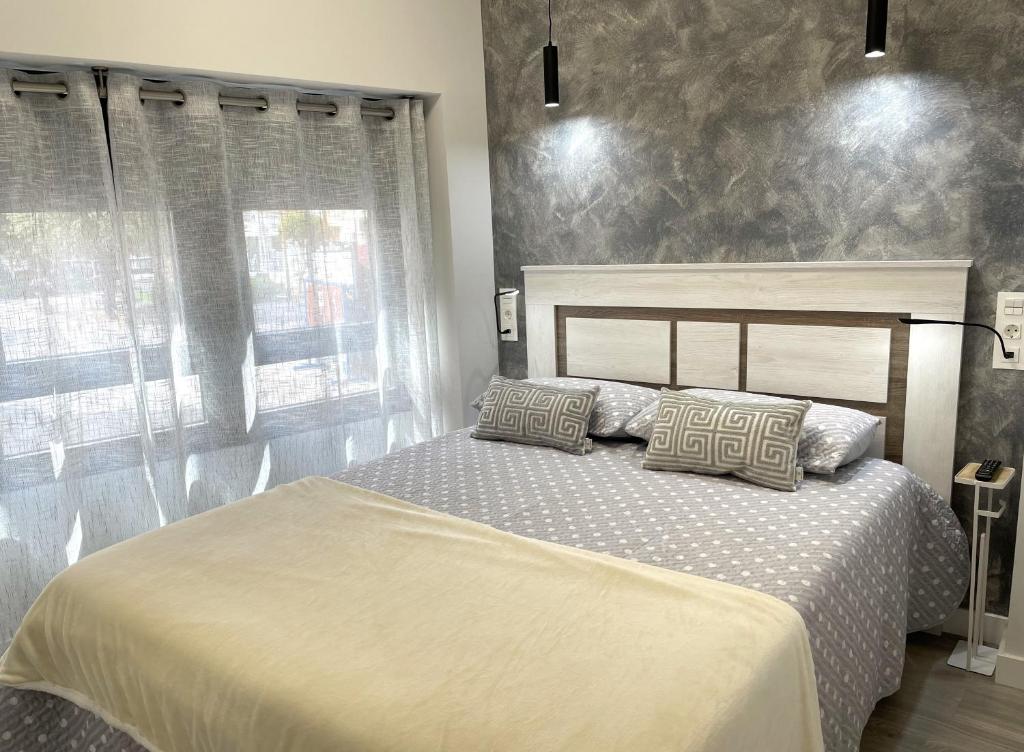a bedroom with a bed with two pillows on it at Apartamentos Aranda - Roble in Aranda de Duero