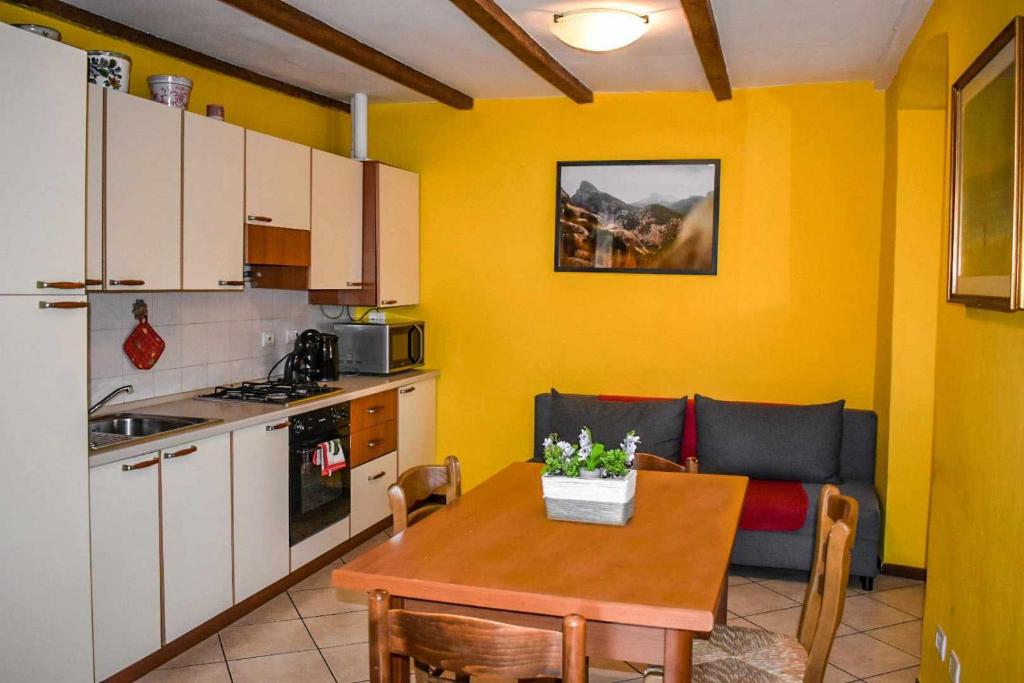 韋爾巴尼亞的住宿－Ciceri Properties Ciancino，一间带桌子的厨房和一间带黄色墙壁的厨房