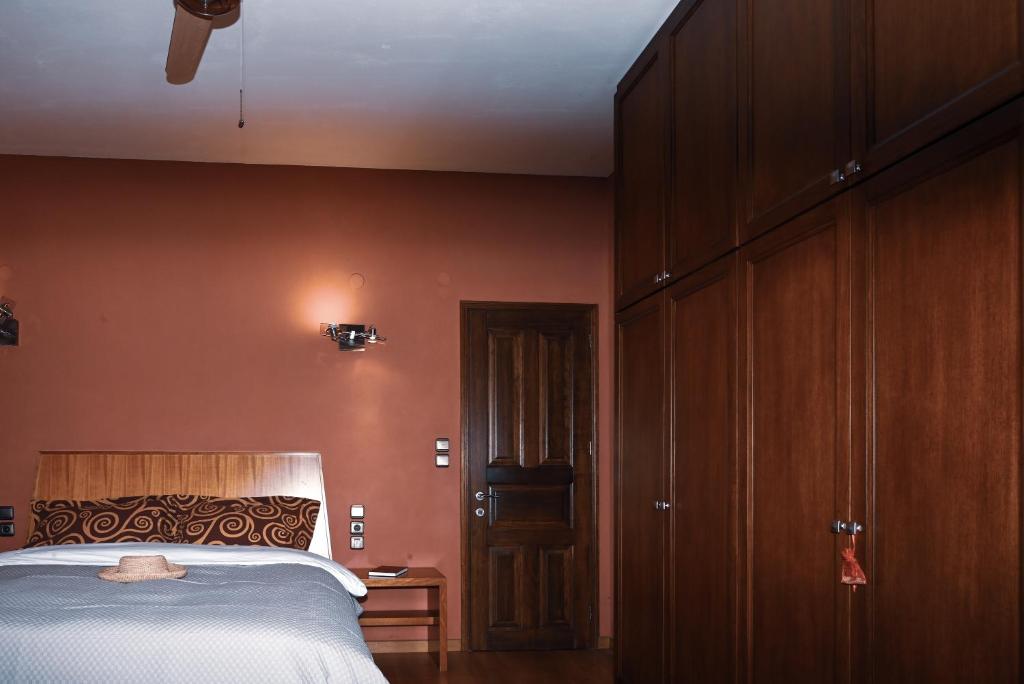- une chambre avec un lit et un mur marron dans l'établissement ARKPelion, à Tsagkarada
