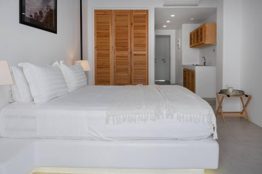 uma grande cama branca num quarto com uma cozinha em Luxury Apartment Center of Mykonos Town - Sleeps 4 em Míconos