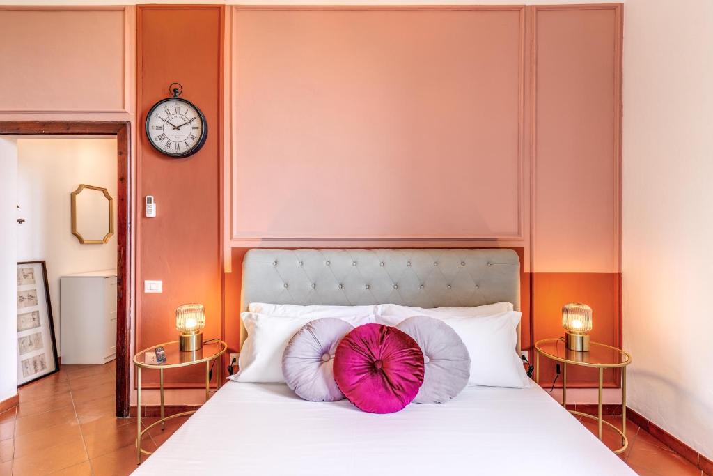 1 dormitorio con cama con almohadas y reloj en AwesHomeitaly - Villa Tower, en Pisa