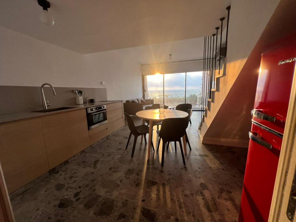 cocina con mesa y sillas en una habitación en דירת גן על הים בנהריה, en Nahariyya