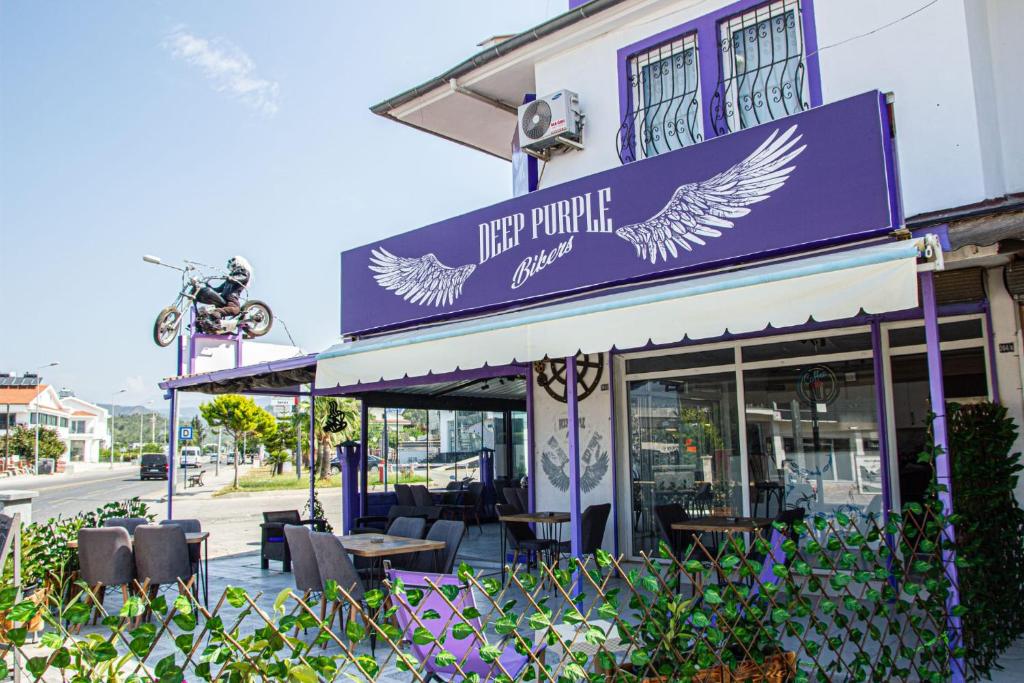 a restaurant with a purple sign with birds on it at Deep Purple Bikers in Fethiye