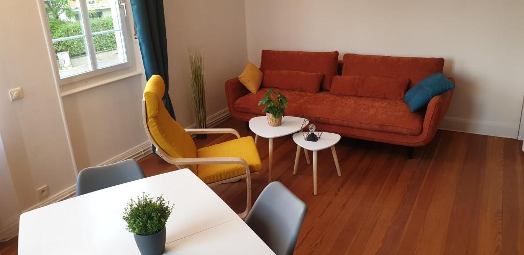 un soggiorno con divano, tavoli e sedie di NOUVEAU !!! Appartement cosy tout confort à deux pas de Strasbourg a Schiltigheim