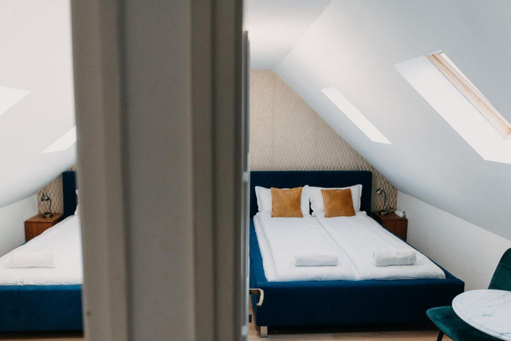 a bedroom with two beds in a attic at Palma Vendégház in Szeged